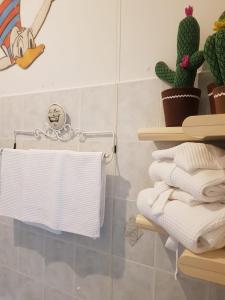 a bathroom with a rack of towels and cactus at Bibi a Mare in Finale Ligure