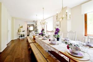 una sala da pranzo con un lungo tavolo e fiori di Westerwald Ferien Villa - 21 Personen - Kino, Bar, Sauna und Whirlpool a Schutzbach