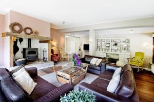 Elle comprend un salon doté d'un mobilier en cuir et d'une cheminée. dans l'établissement Westerwald Ferien Villa - 21 Personen - Kino, Bar, Sauna und Whirlpool, à Schutzbach