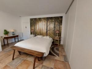 1 dormitorio con 1 cama y una pintura en la pared en Le Clos des 4 Saisons, en La Rochepot