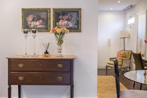 a room with a dresser with a vase of flowers on it at Quinta da Tia Briosa by Madeira Sun Travel in Ponta do Sol