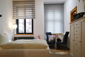 a bedroom with a bed and a table and chairs at HERMANN Hotel Bar in Guben