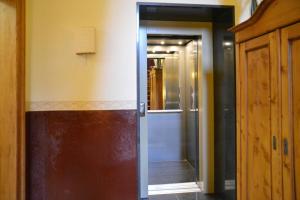 um corredor com uma porta de vidro que leva a uma casa de banho em HERMANN Hotel Bar em Guben