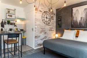 a bedroom with a bed and a desk and a kitchen at Le Manhattan Proche Roissy CDG - Paris - Astérix in Moussy-le-Vieux