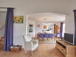 ein Wohnzimmer mit einem TV und einem Tisch mit Stühlen in der Unterkunft Villa with garden near beautiful golf course in Vasles