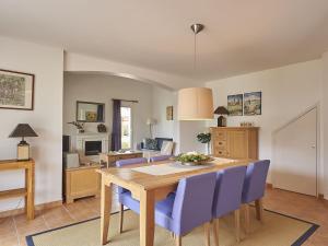 ein Esszimmer mit einem Tisch und blauen Stühlen in der Unterkunft Villa with garden near beautiful golf course in Vasles