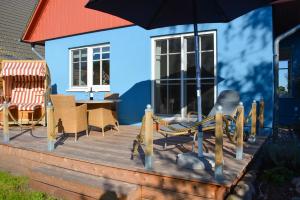 a wooden deck with chairs and an umbrella at Wieckend in Wieck
