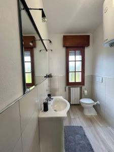 a white bathroom with a sink and a toilet at Holiday home in La Maddalena
