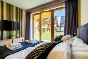 sypialnia z łóżkiem, telewizorem i oknem w obiekcie Podhalańskie Uroki by Apart Concept Podhale w mieście Kościelisko