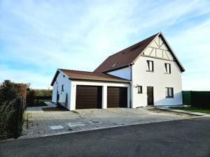 uma casa branca com duas portas de garagem em Studio centre Alsace proche EuropaPark+Rulantica+Strasbourg em Osthouse