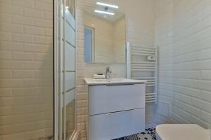 Un baño blanco con lavabo y ducha. en Welcome to Lucie House, en Marly-le-Roi