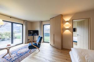 um quarto com uma cama, uma mesa e uma cadeira em Hotel Pacherhof em Bressanone