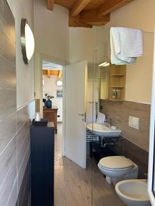 ein Badezimmer mit 2 WCs und einem Waschbecken in der Unterkunft Menaggio Down Town in Menaggio