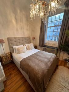 ein Schlafzimmer mit einem großen Bett und einem Kronleuchter in der Unterkunft Salt Life Haven in Brighton & Hove
