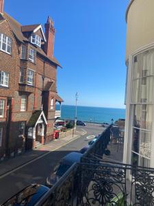 einen Balkon mit Blick auf eine Straße und das Meer in der Unterkunft Salt Life Haven in Brighton & Hove