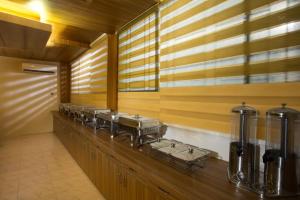 Memento Suites an Airport Hotel في داكا: صف من الأطباق المعدنية على منضدة في مطبخ
