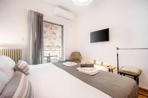 a bedroom with a bed with a tv on the wall at Top Acropolis Sightseeing 1st FLR Elegant Flat by LODGESPOT in Athens