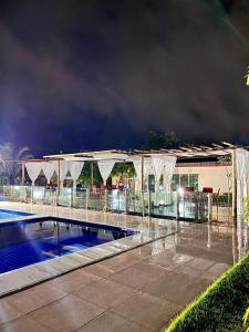 uma piscina em frente a um edifício à noite em Condomínio encantador em Caruaru