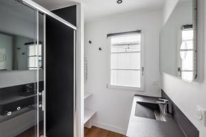uma casa de banho com uma cabina de duche em vidro e um lavatório. em Appartements Le 31bis em Rennes