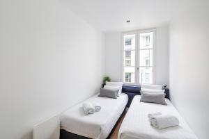3 Betten in einem Zimmer mit Fenster in der Unterkunft Appartements Le 31bis in Rennes
