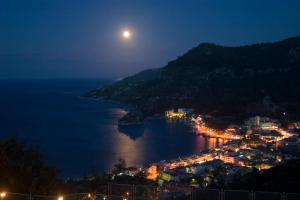 a view of a city at night with a full moon at Loryma Resort Hotel in Turunç