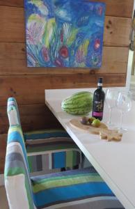 uma mesa com uma garrafa de vinho e um pepino em Shangri-La & Orchid Cottage home em Governorʼs Harbour