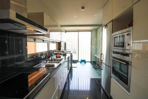 a large kitchen with black counters and a large window at Refúgio Rio Douro in Porto