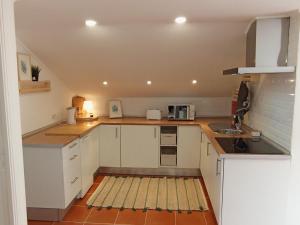 a small kitchen with white cabinets and a sink at Refúgio do Seixal in Seixal