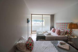 a hotel room with two beds and a window at Refúgio Rio Douro in Porto
