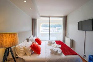 um quarto com uma cama grande e almofadas vermelhas em Refúgio Rio Douro em Porto