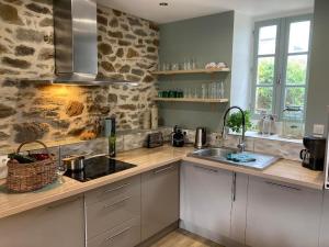 a kitchen with a sink and a counter top at La Maison de Mano in Plouër-sur-Rance