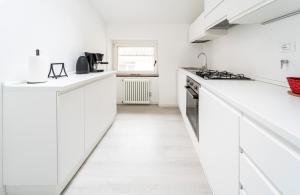 una cocina blanca con encimeras y electrodomésticos blancos en Maison Bohémienne, en Trieste