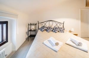 1 dormitorio con 1 cama grande y 2 toallas en Maison Bohémienne, en Trieste