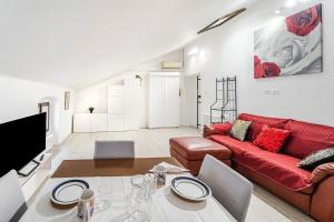 sala de estar con sofá rojo y mesa en Maison Bohémienne, en Trieste