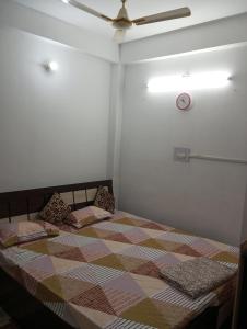 1 dormitorio con 1 cama grande y ventilador de techo en Darbar Homestay, en Gaya