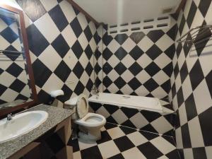 a bathroom with a black and white checkered wall at Rock Shore Patong in Patong Beach