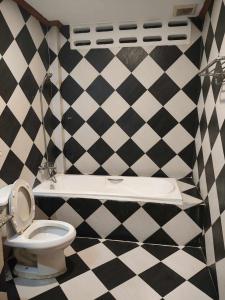 La salle de bains est pourvue d'un mur en damier noir et blanc. dans l'établissement Rock Shore Patong, à Patong Beach
