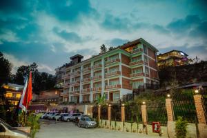 ein großes Gebäude mit Autos auf einem Parkplatz in der Unterkunft Hotel Monalisa Kathmandu Pvt. Ltd in Kathmandu