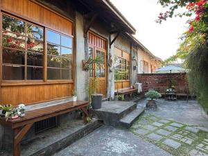 高雄月光寶盒旅店 Moonlight Hostel的门廊,房子里设有长凳和桌子