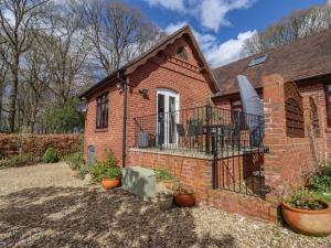 uma casa de tijolos com varanda e vasos de plantas em Beau Cottage em Bewdley
