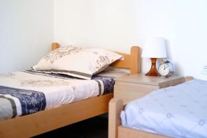 - une chambre avec un lit et une table de nuit avec une lampe dans l'établissement Nomad apartments, à Skopje