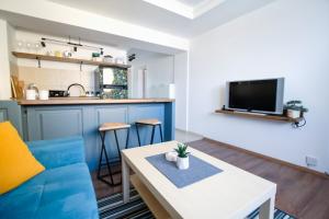 - un salon avec un canapé bleu et une table dans l'établissement Nomad apartments, à Skopje