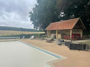 a swimming pool with a pavilion next to a house at Maison de campagne in Sancergues