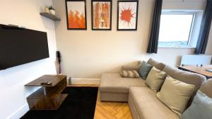 a living room with a couch and a flat screen tv at Refined Living with Free Wi-Fi and Parking in Rickmansworth