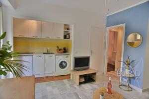 a kitchen with a washing machine and a tv in it at Fully equipped beach studio in Cagnes-sur-Mer
