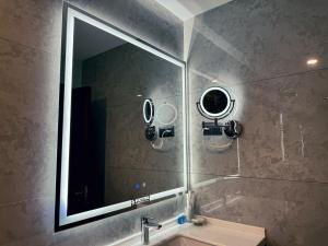 baño con espejo y lavabo en Ziyorat Luxury en Ferganá