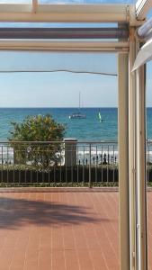 una vista sull'oceano da un balcone con una barca in acqua di Residence Onda Etrusca a San Vincenzo