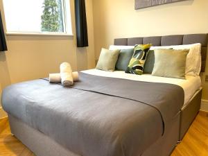 Una cama grande con dos animales de peluche encima. en Refined Living with Free Wi-Fi and Parking en Rickmansworth