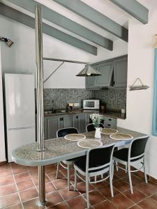 a kitchen with a table with chairs and a refrigerator at Bungalow Tropical nº6 - Son Xoriguer in Son Xoriguer