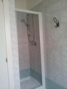 y baño con ducha y puerta de cristal. en Residence Onda Etrusca, en San Vincenzo